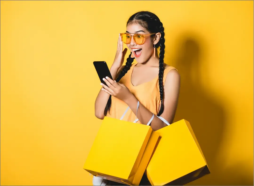 Enthusiastic shopper using a smartphone, showcasing Trinergy’s app designed to enhance customer loyalty and retail engagement.