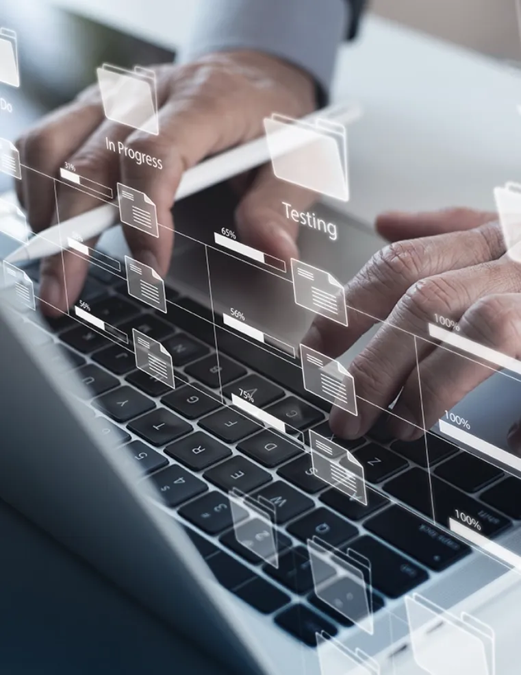 Hands typing on a laptop keyboard with digital project management visuals