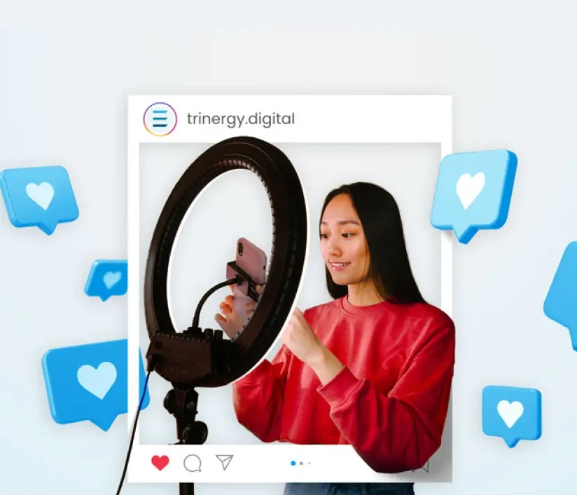 Woman creating social media content with a smartphone and ring light, illustrating social media campaign production by Trinergy.